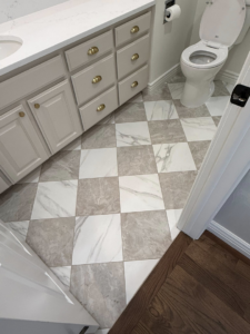Close-up of newly installed checkered marble tile flooring in a bathroom by Patriot Tile LLC in Skiatook, OK.