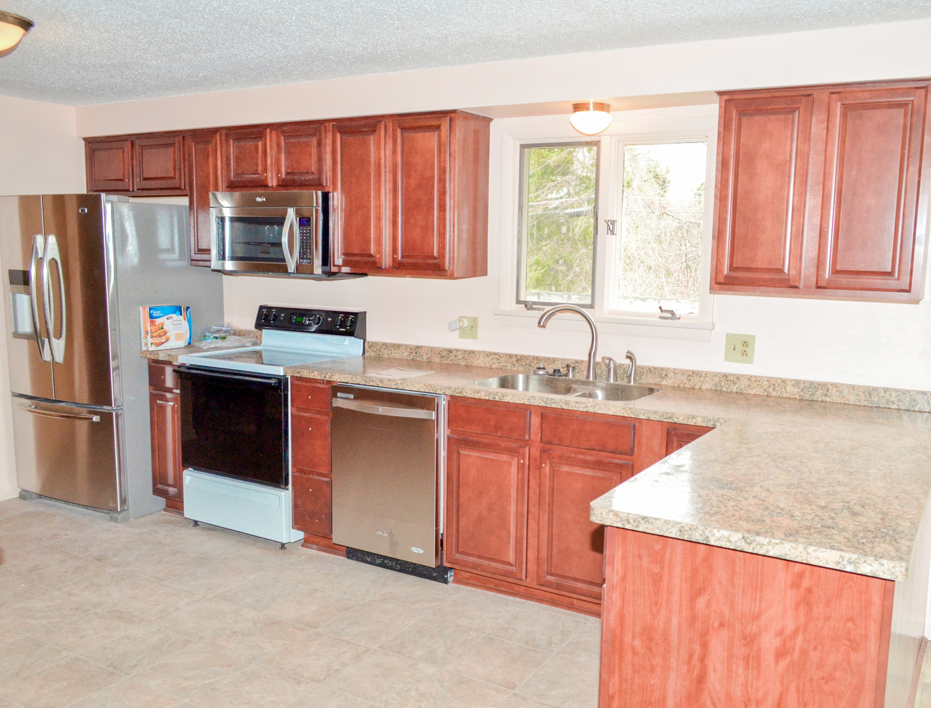 A renovated kitchen featuring cherry wood cabinets and stainless steel appliances by Patriot Construction in Rochester, NY