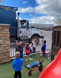 Children watching a Uribe Refuse Services garbage truck from a playground in Lincoln, NE.