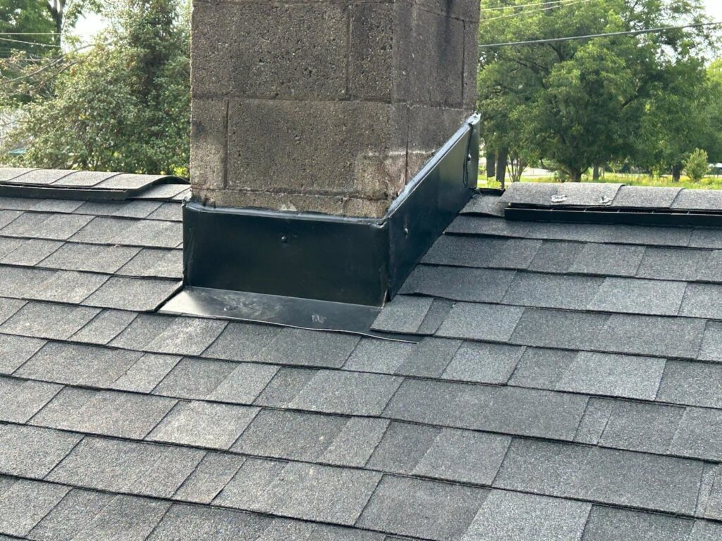 Detailed view of chimney flashing expertly installed on a shingle roof by Roofing Experts Care in Charlotte, NC.
