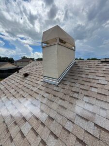 A chimney with new flashing on a shingle roof, demonstrating work by JON Construction, Inc. in Allentown, PA.