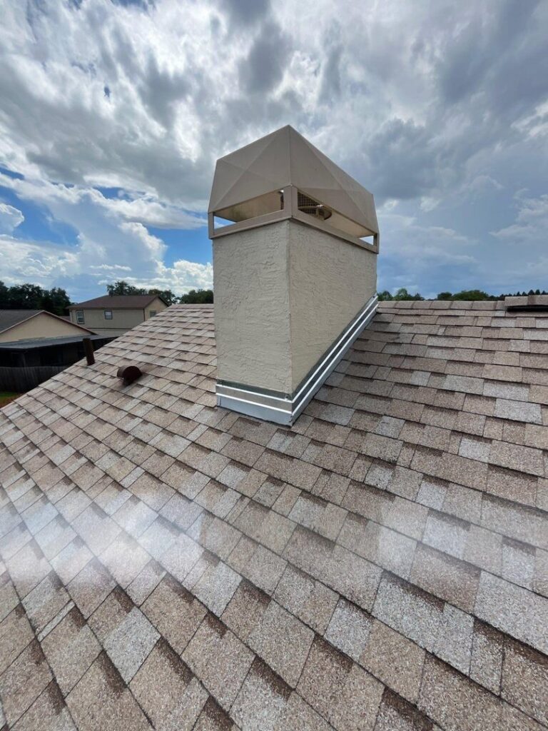 A chimney with new flashing on a shingle roof, demonstrating work by JON Construction, Inc. in Allentown, PA.