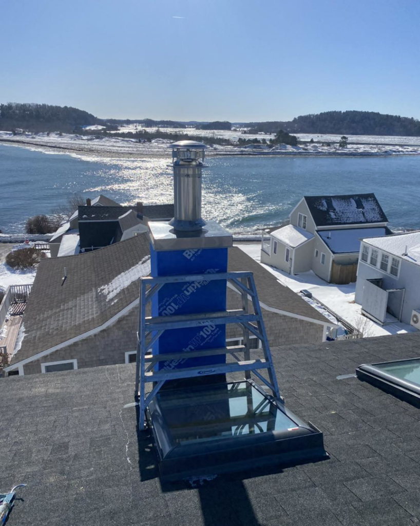 A new chimney installation in progress on a rooftop by Spinosa Construction And Maintenance in Tewksbury, MA.