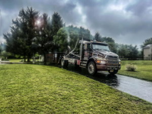 A Christensen Recycling dumpster truck driving on a wet rural driveway in Sayreville, NJ.