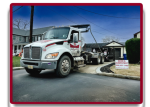 A Christensen Recycling truck pulling a dumpster down a residential street in Sayreville, NJ.