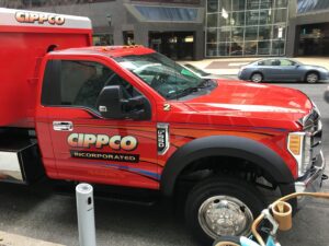 Front and side view of a Cippco Inc. red dump truck, used for general contracting projects in Philadelphia, PA.