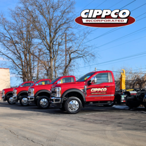 A fleet of red Cippco Inc. dump trucks parked, ready for general contracting projects in Philadelphia, PA.