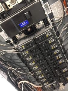 Close-up of wiring and circuit breakers inside an electrical panel by Gragg Electrical Services, LLC in East Canton, OH.