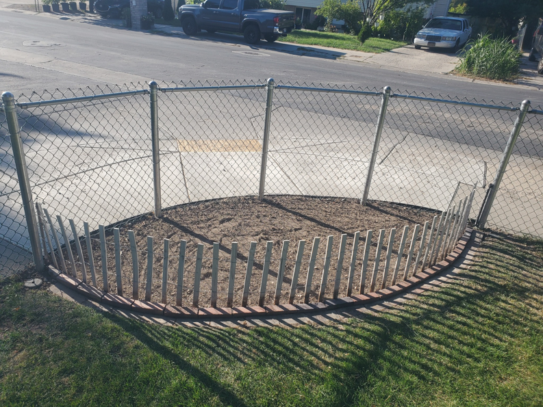 A circular garden bed prepared with bare soil by Papa Bear's Home Care in West Valley City, UT.