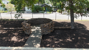 Aerial view of a circular log structure with a wooden walkway in a park by Paradigm Contracting LLC in Wichita, KS.