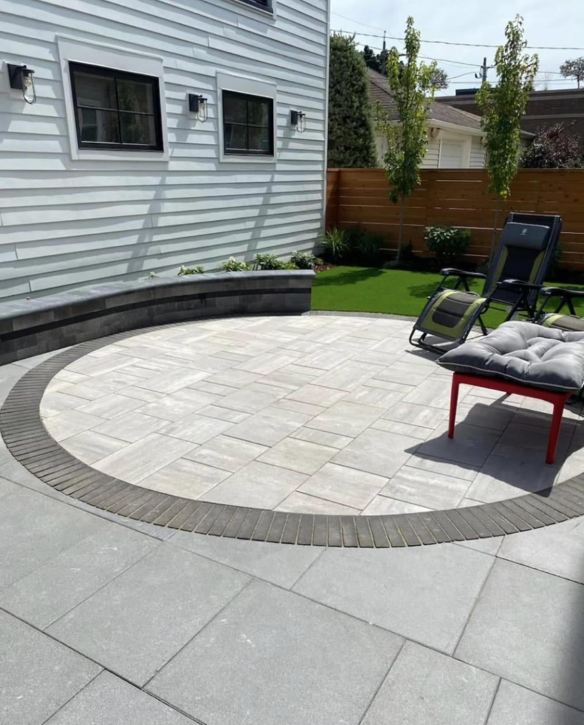 A custom circular patio with a seating wall installed next to a house by Alanis Solutions LLC in Milwaukee, WI