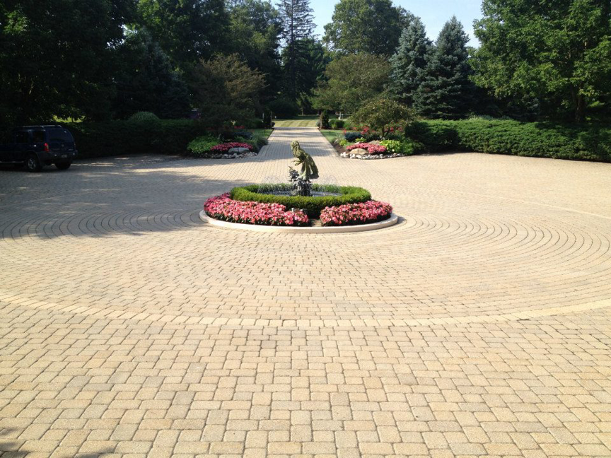 A grand circular paved driveway with a central fountain and flower bed by Massa Paving Company in Cincinnati, OH.