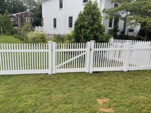 A classic white picket fence with a sturdy gate, professionally installed by Fence Factory Inc in Stamford, CT