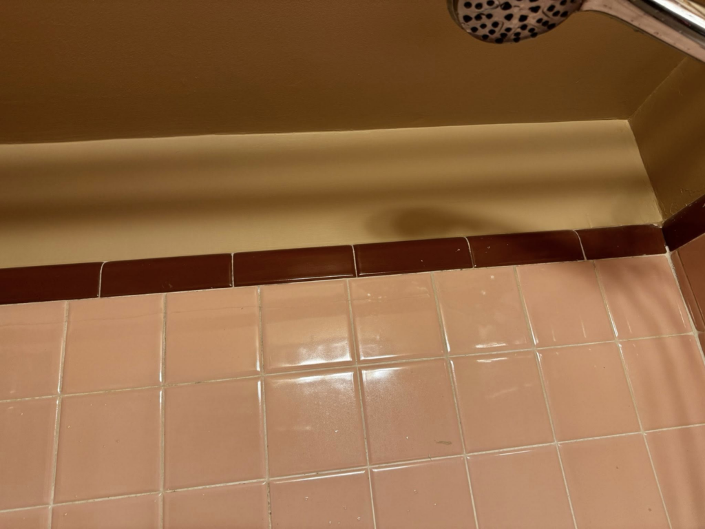 Close-up of clean bathroom tile and painted wall, showcasing quality work by S & H Painting and Drywall LLC in Montgomery, AL.