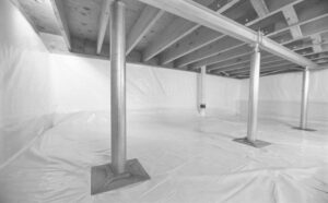 A clean crawlspace with white vapor barrier and new structural support posts installed by Appalachian Foundation Services in Roanoke, VA.