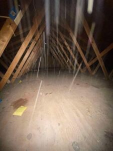 A clean and empty attic space with exposed wooden beams, showing a completed cleanout by DC'S Removal Service in Neelyville, MO.