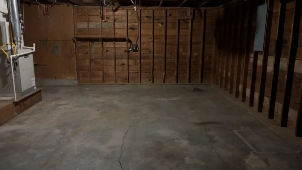 A clean and empty basement or garage with wooden walls, cleared out by 575 Junk Removal in Clovis, NM.