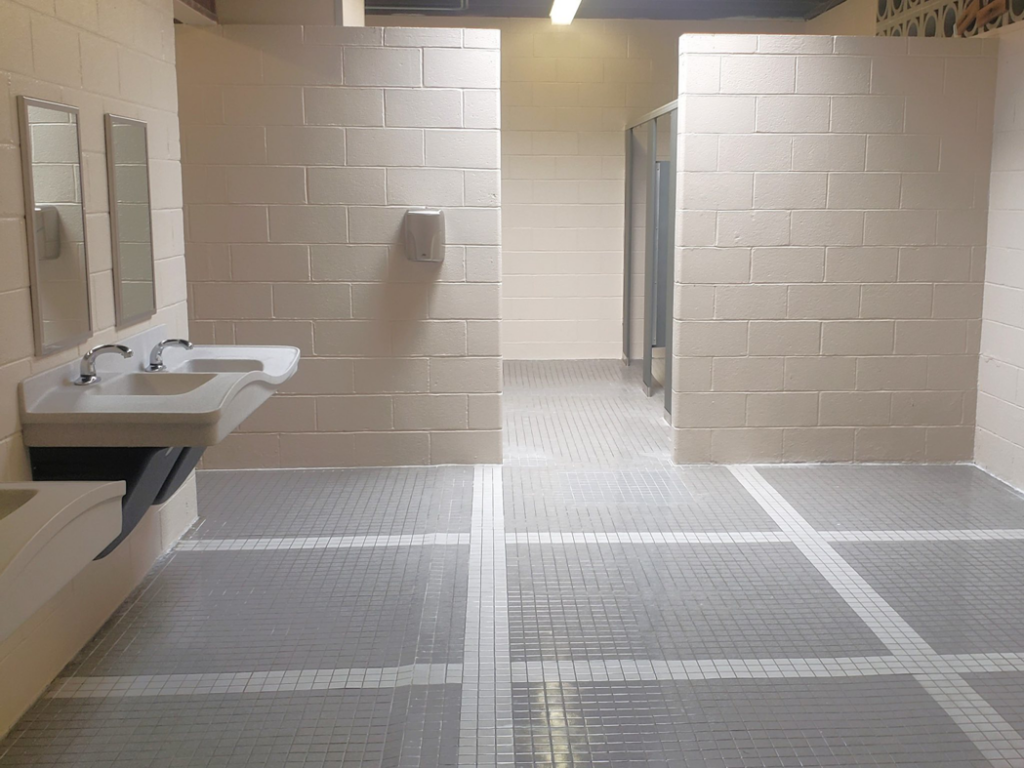 A clean public restroom featuring new tiled floors, sinks, and mirrors installed by J. Forrest Development, LLC in Matthews, NC.