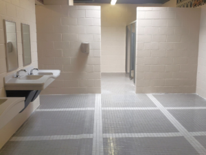 A clean public restroom featuring new tiled floors, sinks, and mirrors installed by J. Forrest Development, LLC in Matthews, NC.
