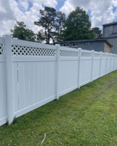 A freshly cleaned white vinyl fence in a backyard by Comeaux Home Services in Baton Rouge, LA.