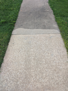 A section of a concrete sidewalk after professional cleaning by Precise Drain & Home Services in Springdale, AR.