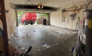 A clean and empty garage after a junk removal service by Junk King Plano, TX, with their truck outside.