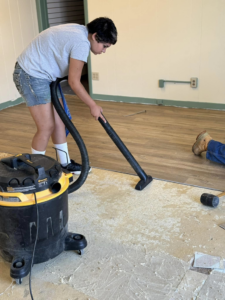 A person vacuuming the subfloor during a renovation project by Wheeler's Handyman Services in Vermillion, SD