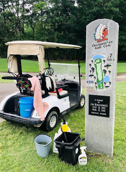 Cleaning supplies and a golf cart next to a stone monument at Occoneechee Golf Club by Stone Cold Restorations in Durham, NC.