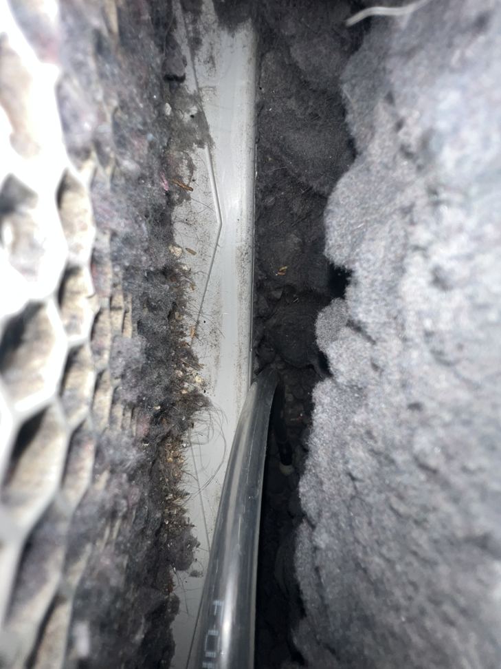 A cleaning tool inserted into a very dirty, lint-filled vent, demonstrating service from Elite Vent Cleaning in Bluebird Lane.