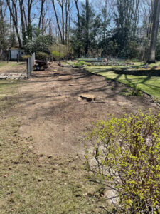 A cleared residential backyard area, showing the results of stump and tree removal services by Grin & Grind Stump Removal LLC in Worcester, MA.