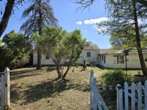A beautifully cleared backyard with a white picket fence, showcasing the results of junk removal by JOLTZ Junk Removal in Dayton, OH.