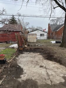 A cleared backyard area, showing the successful removal of a shed or structure by Prestige Junk Removal & Hauling in Detroit, MI.