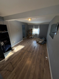 A room largely cleared of clutter, demonstrating a partial junk removal or cleanout job by DJ's Junk Removal in Laconia, NH.