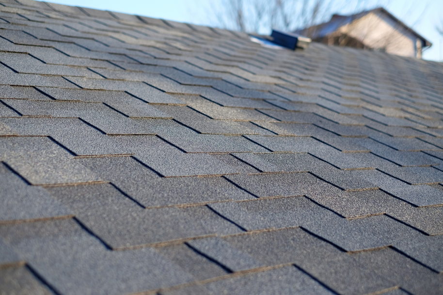 Close-up of dark asphalt shingles on a residential roof, showcasing exterior work by Coburns interior and exterior in Services Available In.