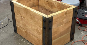 A close-up view of a custom-built wooden raised garden bed with metal corner details by PNW Home Improvements, LLC in Portland, OR