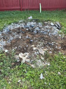 A close-up of debris, rocks, and dirt in a yard, indicating a cleanup job by Dumpin' Junk in Martinsburg, WV.