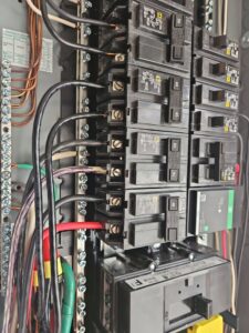 A close-up view of an open electrical panel with circuit breakers and wiring, serviced by MorLite Electric in Newport News, VA.