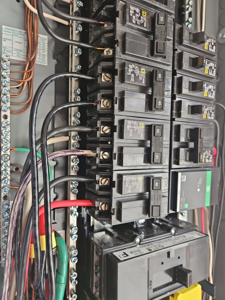 A close-up view of an open electrical panel with circuit breakers and wiring, serviced by MorLite Electric in Newport News, VA.
