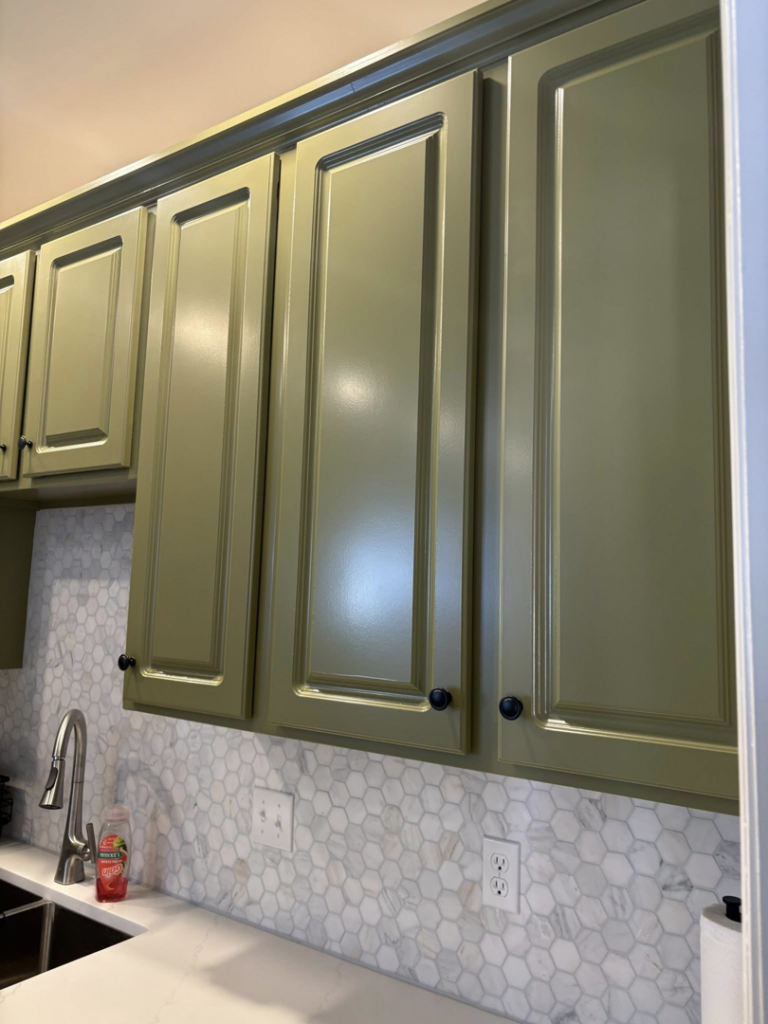 Close-up of newly painted green kitchen cabinets and a white honeycomb backsplash installed by Mauricio's Home Improvements in Raleigh, NC.