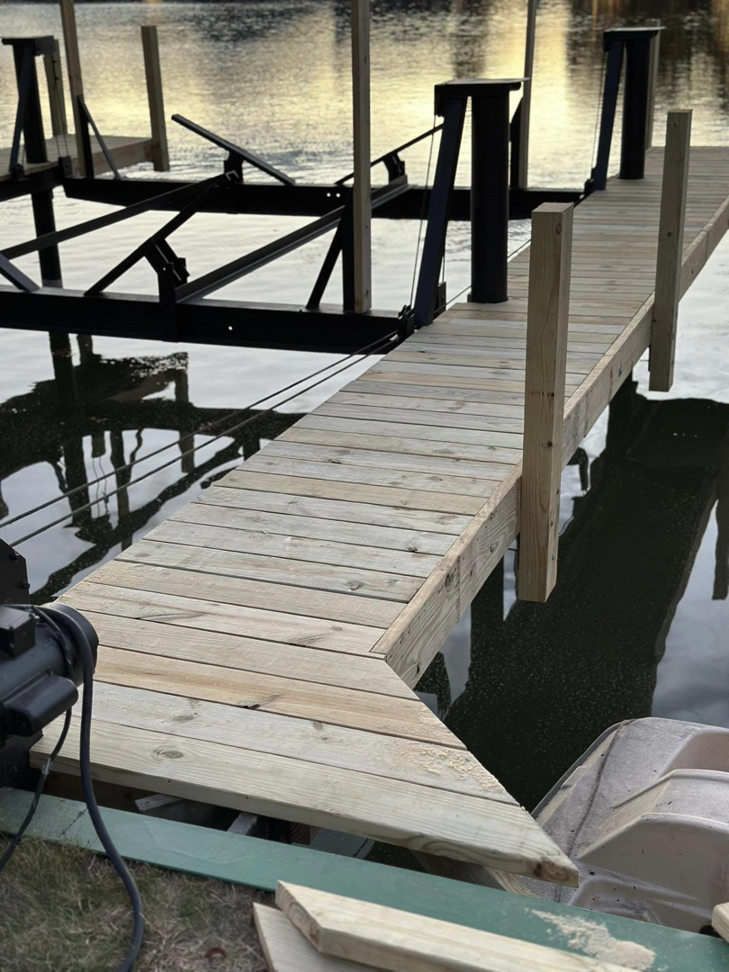 A close-up view of new wooden dock planks and boat lift structure by TopNotch Remodeling & Restoration Service LLC in Warren, MI