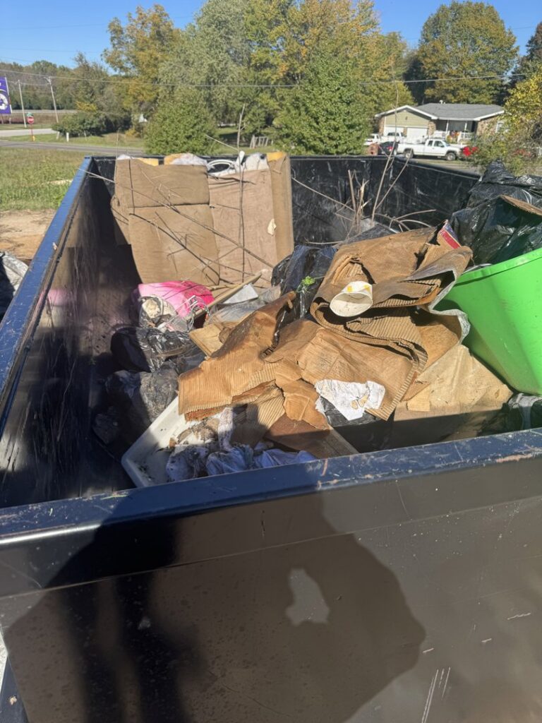 A close-up view of cardboard boxes and debris inside a Waste Walkers Dispatch dump trailer in Springfield, MO.