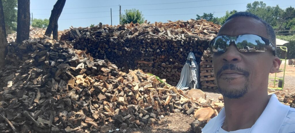 A close-up view of neatly stacked firewood, ready for delivery or use, from Personal Touch Tree Service in Dallas, TX.