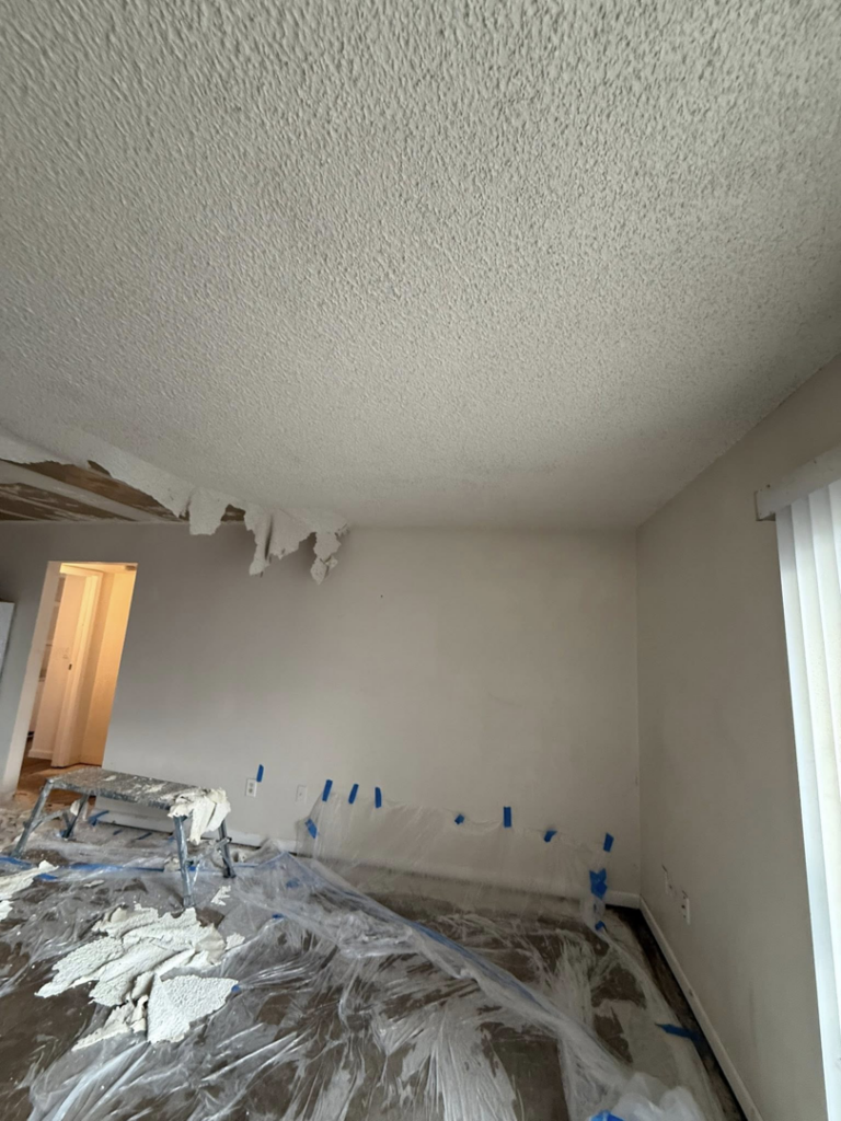 A close-up view of a popcorn ceiling with texture being removed during a remodeling project by AM Remodels LLC in Denver, CO.