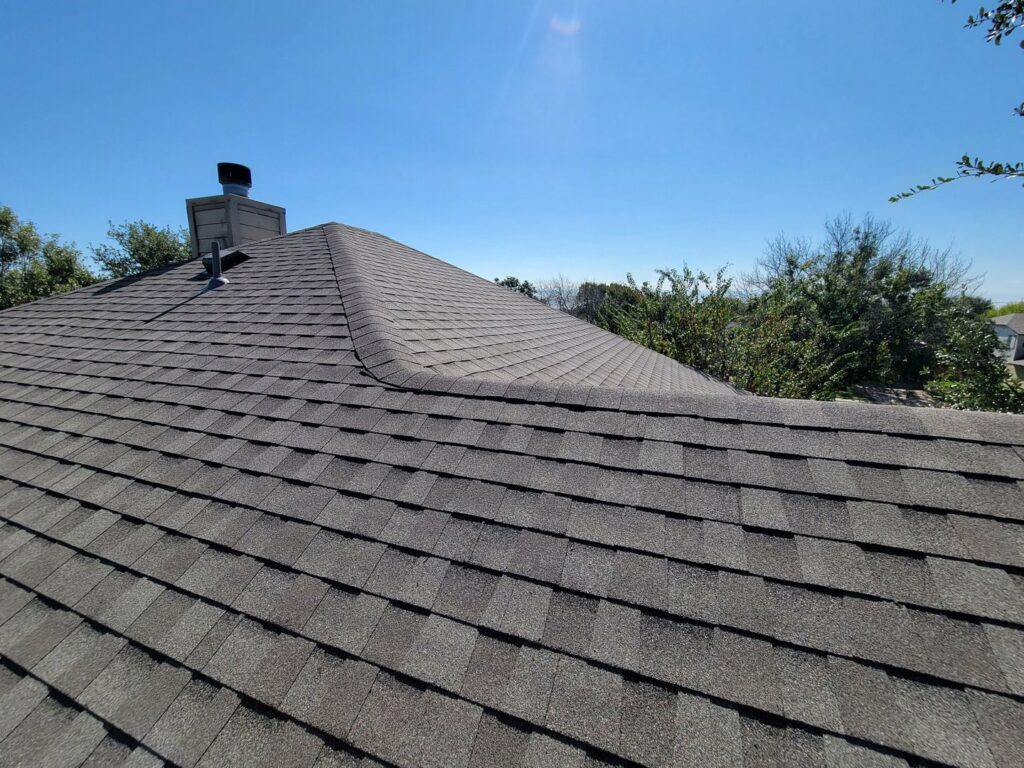 Close-up view of a residential roof with new asphalt shingles installed by Austin Roofing and Construction in Austin, TX.