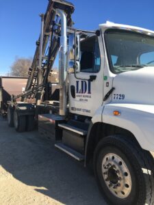 A close-up view of a white LDI roll-off truck, showcasing the equipment of Liberty Disposal, Inc. in Tucson, AZ.