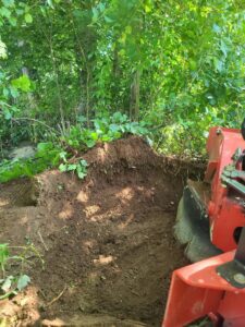 A close-up view of a stump grinder actively removing a tree stump, demonstrating services by Grin & Grind Stump Removal LLC in Worcester, MA.