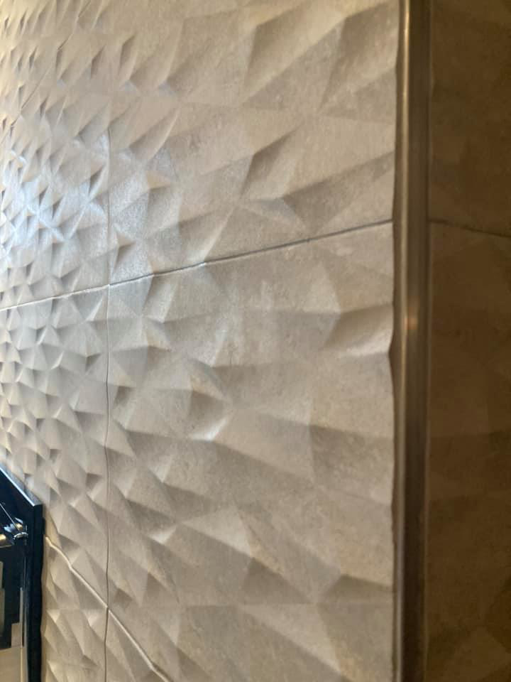 Close-up view of intricate textured tile work on a fireplace wall by Old Style European Stucco & Masonry in Brentwood, TN