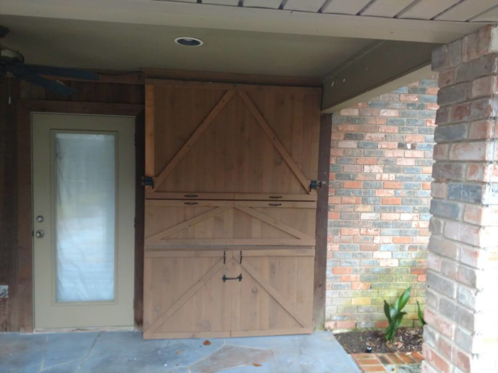 A custom outdoor cabinet with barn-door style panels, fully closed, built by Rex Austin's Remodeling in Ball, LA.