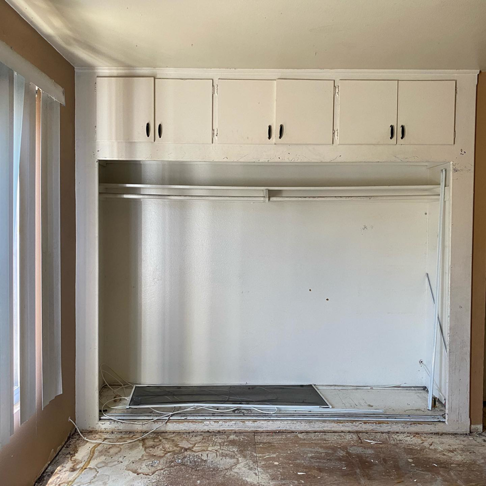 A closet area undergoing renovation with exposed subfloor and wiring by Premier Home Services in Fullerton, CA