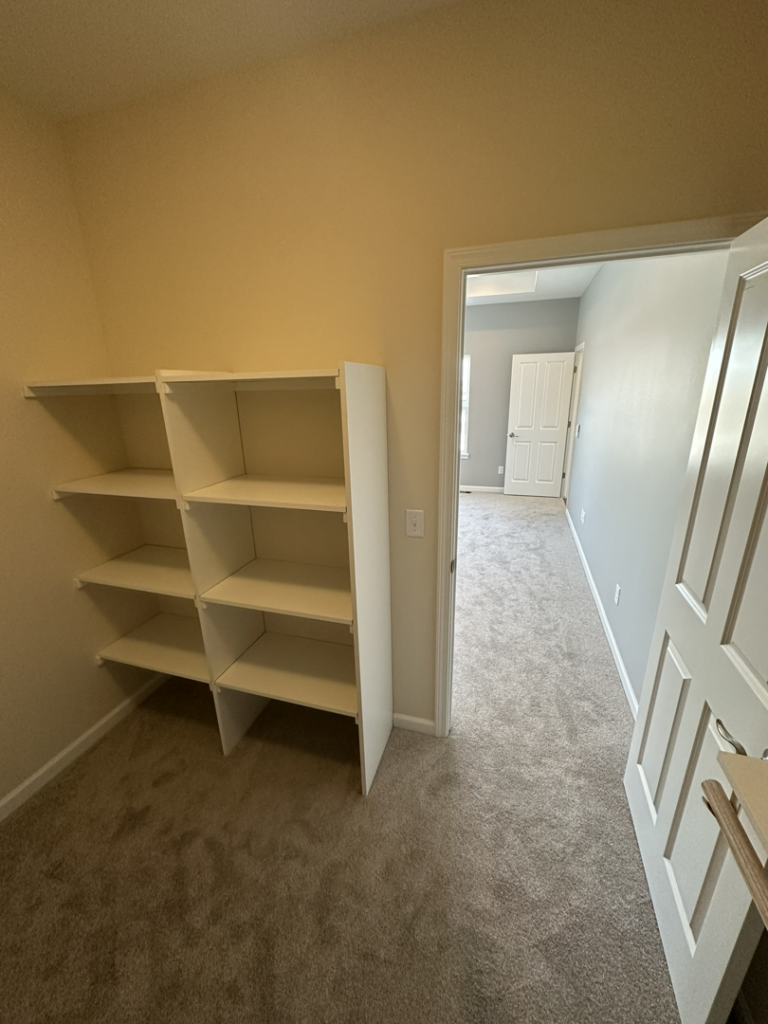 Newly installed white shelving units in a closet by Harpe Development LLC in Kenosha, WI.